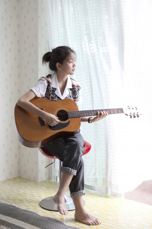 face of asian woman playing guitarの写真素材