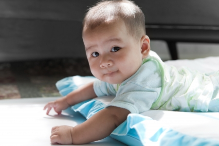 face of asian baby lied on bed in living roomの写真素材