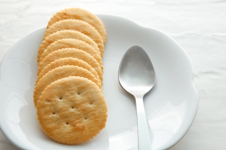 biscuit cracker on white plate with tea spoonの写真素材
