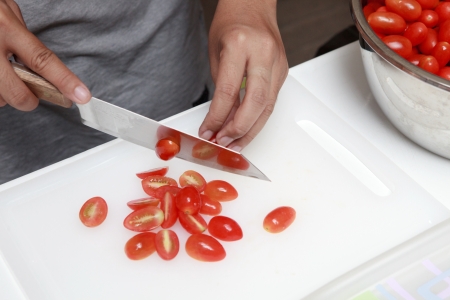 Hand and Knife Slicing Tomato の写真素材