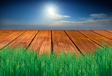 wood terrace with green grass fore ground sun blue sky background の写真素材