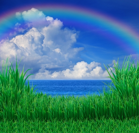 green grass field and sea sky white cloud rainbowの写真素材