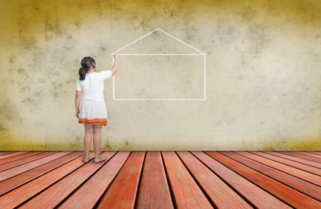 girl writing out line of home on concrete wall の写真素材