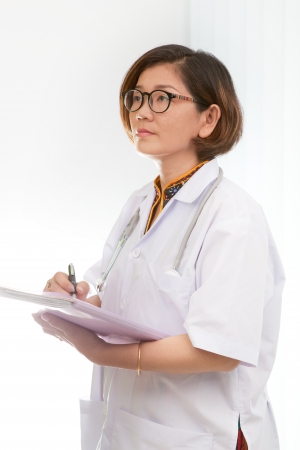 female doctor holding working paper document and watching to reading reportの写真素材