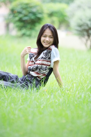 face of asian woman relaxing emotion sitting on grass field の写真素材