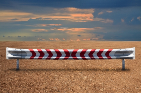 hard steel guardrail on soil land with dramatic colorful skyの写真素材