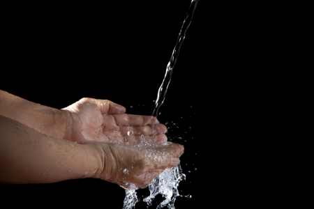 file of hand and pouring water on black backgroundの写真素材