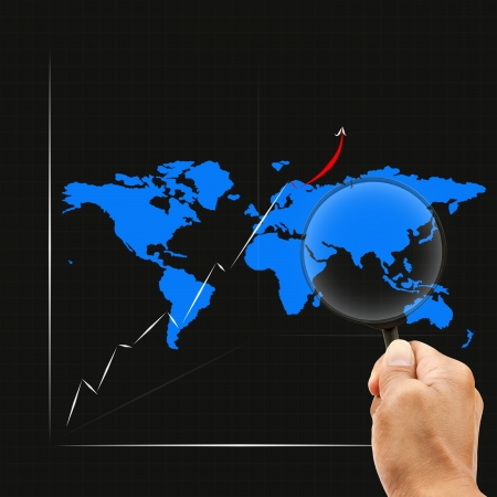 hand and magnifying lens watching on graph map around asiaの写真素材