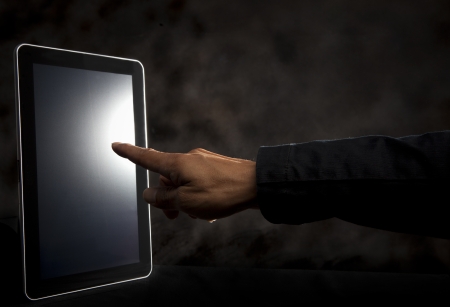 hand point to touching on tablet screen with dark backgroundの写真素材