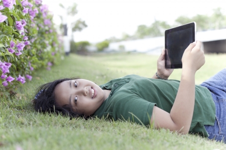 girl and tablet computer on green grass  with relaxing emotionの写真素材