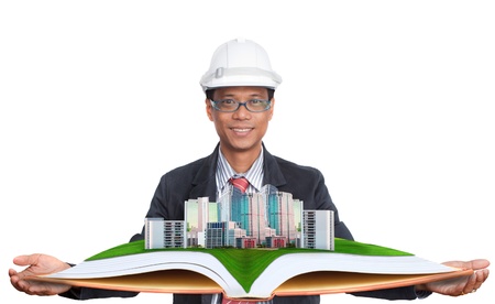 architect holding green field with modern building aboveの写真素材