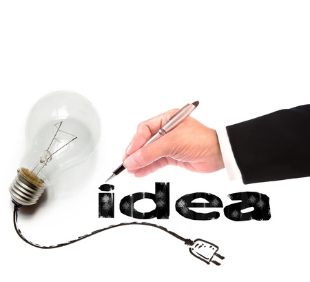 hand of business man writing idea with light bulb besideの写真素材