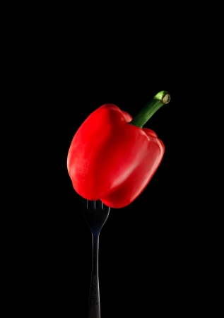 red paprika chilly on fork with black の写真素材