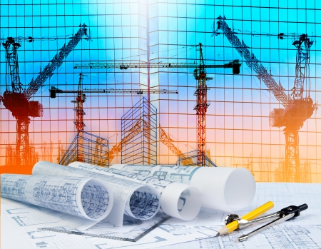 architecture plan on architect working table with building and reflection of crane construction on mirror buildingの写真素材