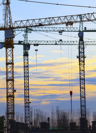 crane of building construction against beautiful dusky sky use for construction industry business and land developmentの写真素材