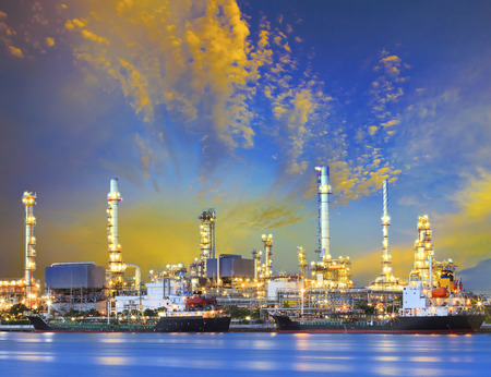 tanker ship and petrochemical oil refinery industry plant with beuatiful lighting against dusky sky...