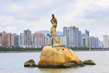  Zhuhai Fisher Girl sculpture important landmark of visitor when visited to  zhuhai city china against residence building background のeditorial素材