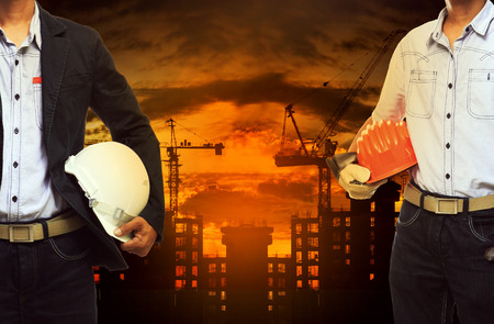 young engineer man standing with safety helmet against building construction siteの写真素材