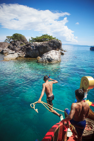 TRAT THAILAND - OCT29 : boat working man with rope jumping to the sea when the boat run into shallow of sea water for snorkeling around the island on October29, 2014 in Trat eastern of  Thailandのeditorial素材