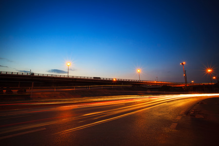 beautiful blue dusky sky peak of twilight time and light painting on asphalt road by vehicle moving use for land transport and urban life backgroundの写真素材
