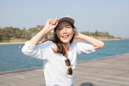 portrait of beautiful woman happy face sitting on wood port sea side use for people activities holiday ,vacation on beachの写真素材