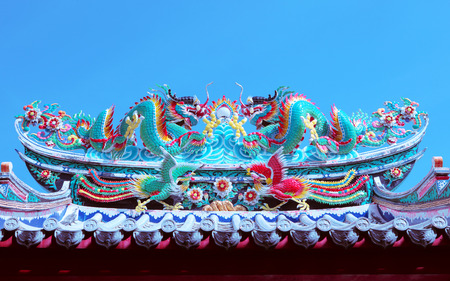 beautiful dragon statue decorated on chinese temple roof against clear blue sky for chises new year background and china culture architecture buildingの写真素材
