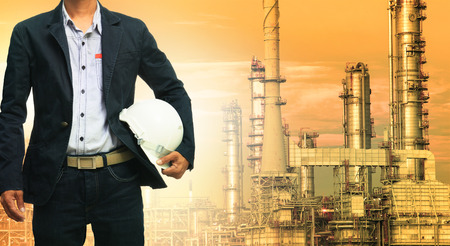 engineering man and safety helmet standing against oil refinery plant in heavy petrochemical industrial estate