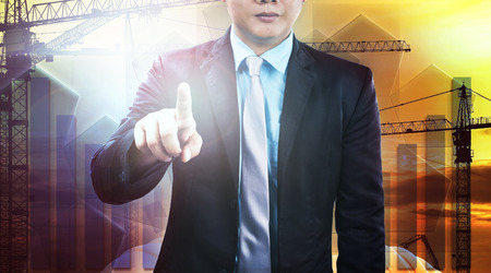 business and engineering man pointing finger to require person to working with construction team against industry site backgroundの写真素材