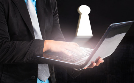 business man and computer laptop and light from key hole use for working solution conceptionの写真素材