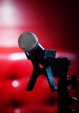 close up texture of microphone in music hall against red luxury backgroundの写真素材