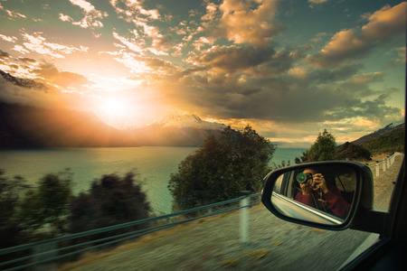 photographer taking a photograph of sun set sky while traveling on the way to lake wakatipu south island new zealandの写真素材