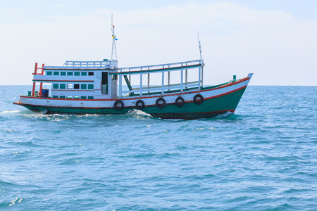 passenger wooden boat in tourist business in thailand floating on sea water isolated white...