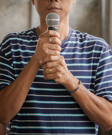 portrait of young asian man and microphone in hand