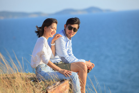 portrait of asian younger man and woman relaxing vacation at sea side happiness emotionの写真素材
