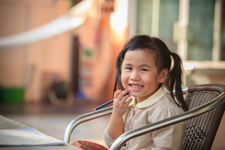toothy smiling face of adorable sian children at home happiness emotionの写真素材
