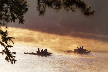 silhouette of tourist bamboo rafting in pang ung at morning mist ,most popular winter traveling destination in maehongson northern of thailandの写真素材
