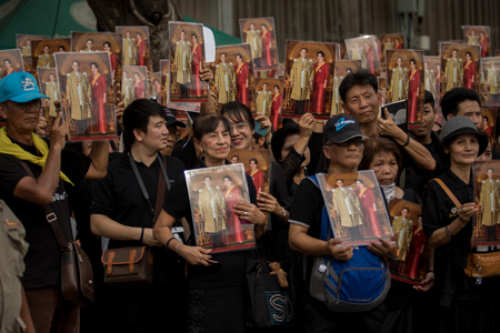 BANGKOK THAILAND - OCTOBER5,2017 : thai mourners people wearing black clothes and carrying king and queen of rama ix bhumibol photograph on last day of respect to their beloved king at grand palaceのeditorial素材