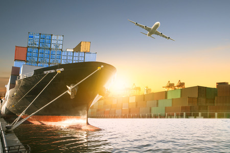 ship and container box and cargo plane flying over shipping dock use for logistic and international transportationの写真素材