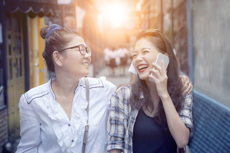 close up face of two asian woman laughing with happiness emotion in shopping streetの写真素材