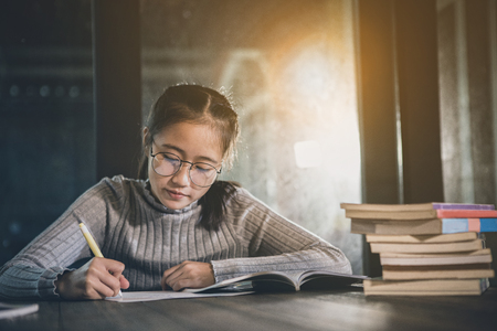 asian teenager doing school home work in library roomの写真素材