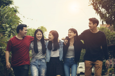 asian younger freelance team laughing with happiness after work project successfulの写真素材