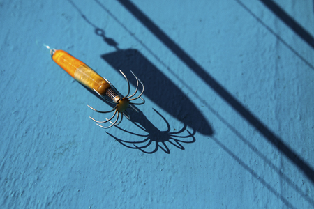 light and shadow of old squid lure on blue wood floorの写真素材