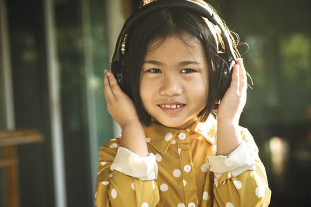 happiness face of asian children listening music in head phoneの写真素材