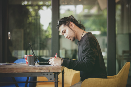 left handed freelance man write project in home working officeの写真素材