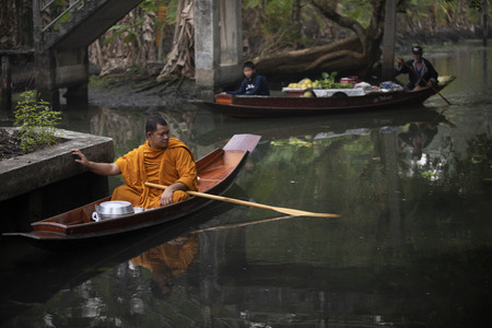 ratchaburi thailand - january11,2019 : thai monk sailing wood boat in narrow canal on dumneon saduak district in ratchaburi for recieving food in early morning  のeditorial素材