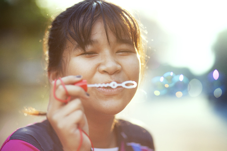 asian teenager relaxing with soup bubble against beautiful sun lightの写真素材