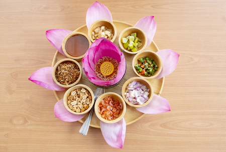 pink lotus petal flower decorated and is part of thai snack food on clear wood tableの写真素材