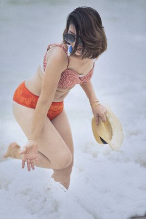 younger woman wearing bikini suit playing with happiness emotion on summer vacation beachの写真素材