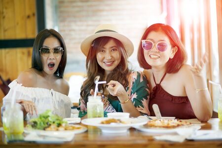 three asian woman ready to eating western food on tableの写真素材