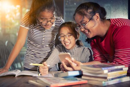 group of asian teenager reading message on smart phoneの写真素材